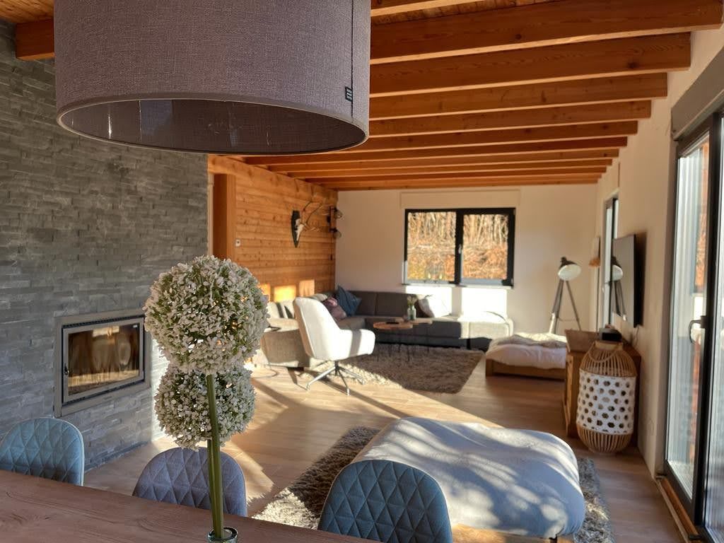 Chalet Presseggersee comfortabele woonkamer met hoekbank, eettafel met 10 stoelen, smart TV, houtkachel